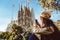 Young woman tourist in front of the famous Sagrada Familia landmark in Barcelona