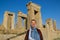 Young woman tourist with a head covered stands on the background of the famous bas-reliefs of the day capital of Persia Iran - P