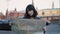 Young woman tourist lost looking at the map, background of red square