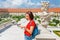 Young woman tourist reading map and admiring amazing view of a flower garden in Bratislava, Slovakia