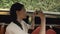 Young woman tourist ride wooden boat in flaoting market in Thailand and photographing ethnic people