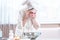 Young woman with a towel on her head washing her face with water in the morning. Hygiene and care for the skin