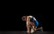 Young woman, track athlete training isolated over black studio background.