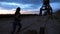 A young woman in a tracksuit jogging along the sand pier of the cargo port, in the twilight of the morning dawn. View