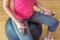 Young woman training in gym with dumbbells, sitting on fitball