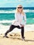 Young Woman Training Sport on Beach Seaside sand with blue Sea on background