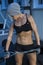 A young woman trains in the gym, in her hands a chain