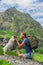 Young woman travel with backpack and dog jack russel in mountain