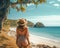 Young woman in travel clothes in hat standing on the beach