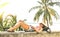 Young woman travel influencer relaxing on stone wall at Phuket beach promenade - Wanderlust vacation concept with adventure girl