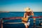 Young woman traveler admiring landscape on pier by Red sea. Summer fashion