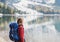 Young woman traveler in Alps mountains looking on a lake. Travel, winter and active lifestyle concept