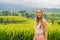 Young woman traveler on Beautiful Jatiluwih Rice Terraces against the background of famous volcanoes in Bali, Indonesia