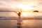 Young woman traveler dancing and enjoying beautiful Sunset on the tranquil beach, Travel on summer vacation concept