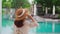 Young woman traveler enjoying a summer vacation at swimming pool in tropical resort near the beach, Travel lifestyle concept