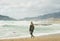 Young woman traveler looking at stormy Mediterranean sea, Alanya, Turkey