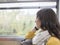 Young woman traveler looking through window inside of suburban train