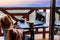 Young woman traveler sits at the terrace with a tablet against beautiful mountain scenery during journey.