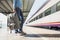 Young woman traveler waiting for a train on a railroad station, travel and active lifestyle concept