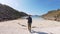 Young woman traveler walking to the beach at the Norwegian fjord.