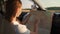 Young woman traveling in an authentic car. A woman holding a tourist map, planning a route, a road trip concept