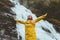 Young woman traveling at waterfall emotional raised hands