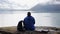 A young woman traveller sitting by the Norwegian fjord