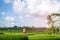 Young woman travelling in Asia, walking with rattan backpack in rice paddies during rainy season in Bali, freedom