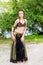 Young woman tribal american style dancer. Girl dancing and posing on the beach sand wearing belly dance costume. Ethnic