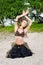 Young woman tribal american style dancer. Girl dancing and posing on the beach sand wearing belly dance costume. Ethnic