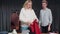 Young woman tries on a red sweater in second hand clothes shop