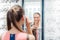 Young woman trying fashionable glasses in optometrist store