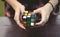 A Young Woman is trying to solve Rubik`s Cube on a Wood table in Stanley Park