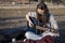 Young woman tuning acoustic guitar at dusk