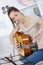 Young woman tuning guitar