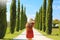 Young woman in Tuscan landscape with cypress trees. Travels in Italy