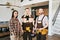 Young woman and two plumbers standing in living-room