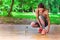 Young woman tying her sneaker shoe on wooden background