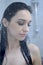 Young woman under shower with water drops