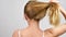 Young woman untying hair. Healthy straight blonde hair