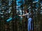 A young woman unwraps a bright yoga Mat in the forest, copy space, Sunny weather, summer. The girl is preparing for practice and