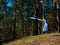 A young woman unwraps a bright yoga Mat in the forest, copy space, Sunny weather, summer. The girl is preparing for practice and