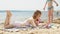 Young woman uses computer tablet on the beach, river bank