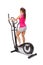 Young woman uses elliptical cross trainer.