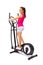 Young woman uses elliptical cross trainer.