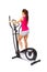 Young woman uses elliptical cross trainer.