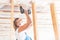 A young woman uses a screwdriver to screw the wood screws into the boards.