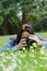Young woman using dslr outdoor laying on grass