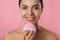 Young woman using facial cleansing brush on background, closeup. Washing accessory