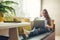 Young woman using her laptop in the livingroom